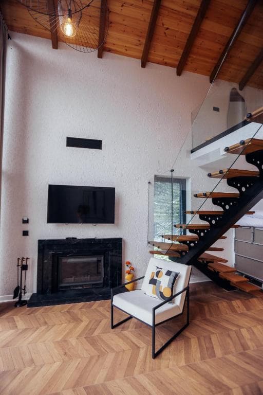 Şömine ve ahşap merdivenli villa iç mekânı