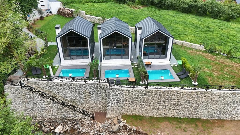 Dere kenarındaki üç villanın drone görünümü