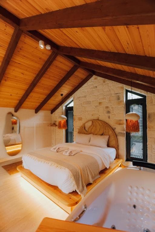 Corner Roof Villa 101 — taş duvarlı loft yaşam alanı ve jakuzi köşesi