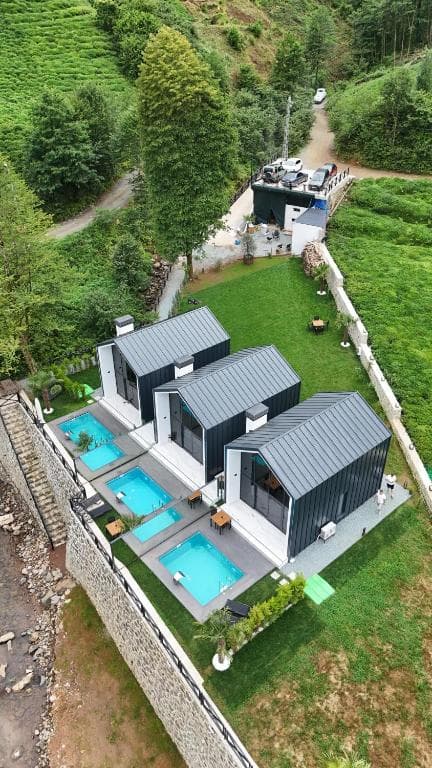 Dere kenarındaki Roof Villa bungalovlarının dikey drone görünümü