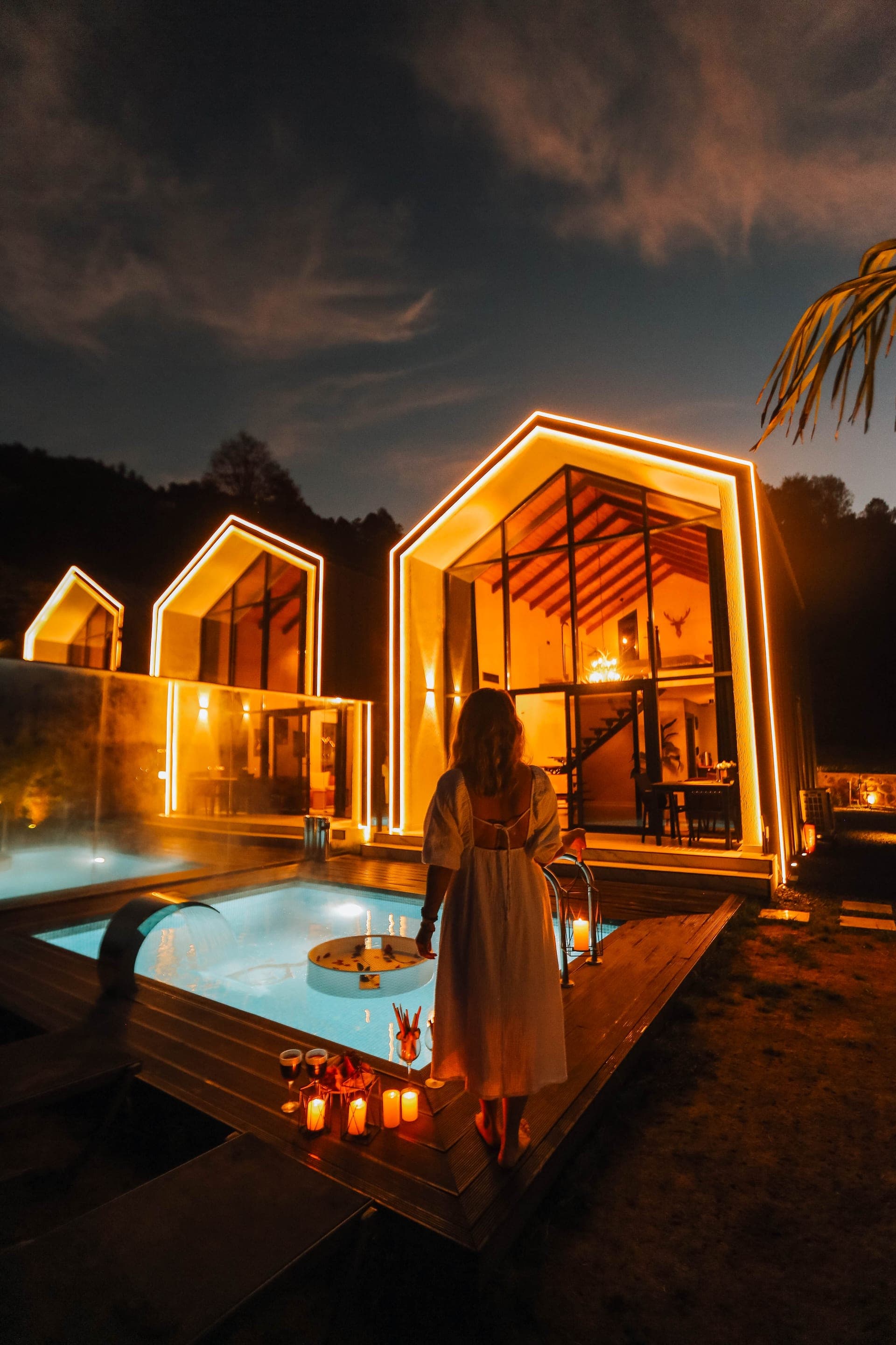 Gece aydınlatmasında buharı tüten ısıtmalı havuzlu bungalov villa